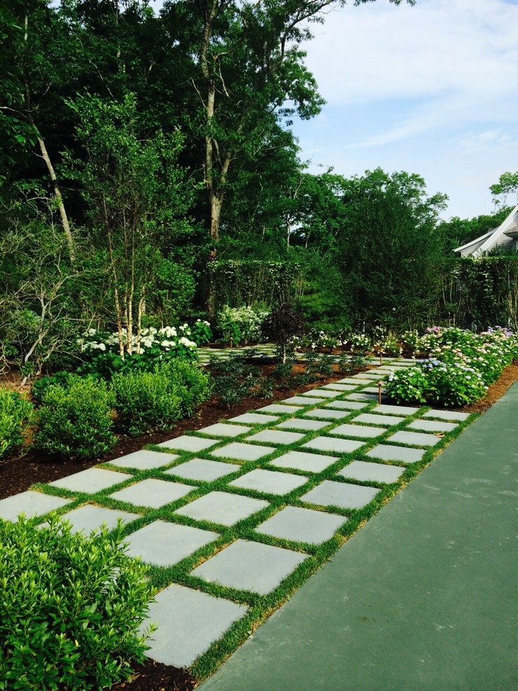 Idée de décoration pour un grand jardin arrière tradition l'été avec une exposition ensoleillée et des pavés en béton.