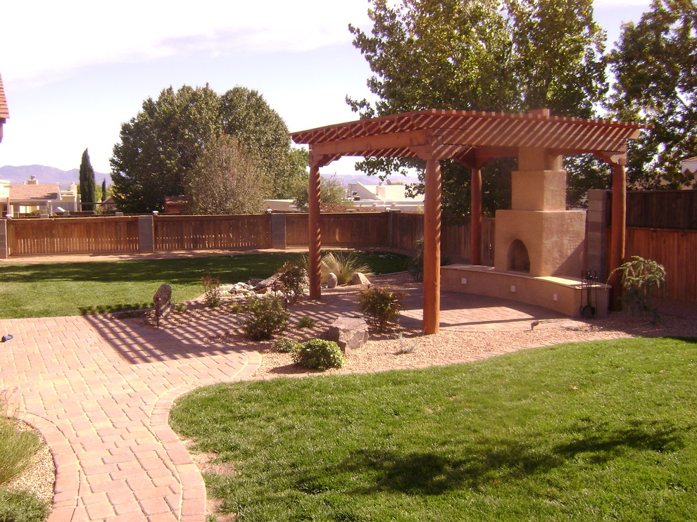 Foto di un giardino xeriscape chic di medie dimensioni e dietro casa con pavimentazioni in mattoni e un caminetto
