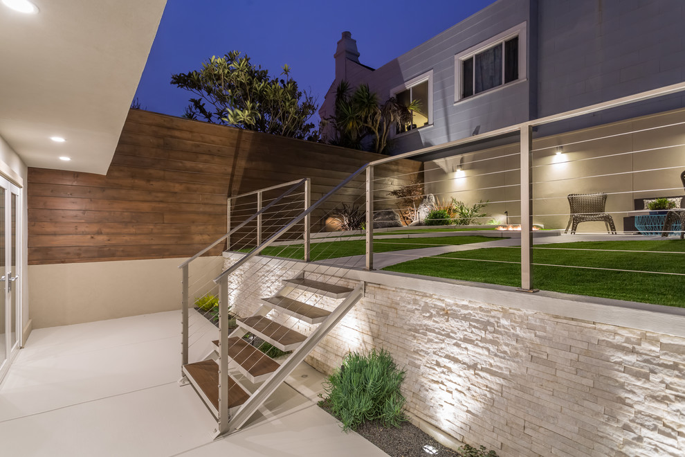 Small contemporary back xeriscape full sun garden for summer in San Francisco with a fire feature and concrete paving.