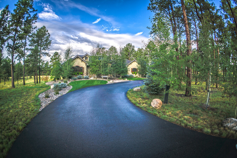 Photo of a large classic front driveway partial sun garden for spring in Denver with concrete paving.