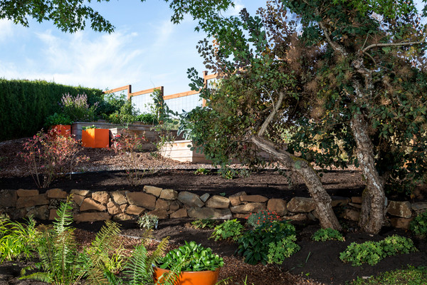 Idee per un grande giardino formale chic esposto a mezz'ombra dietro casa in estate con un muro di contenimento e pavimentazioni in mattoni