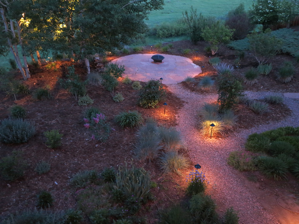 Photo of a large rustic backyard gravel landscaping in Denver with a fire pit.