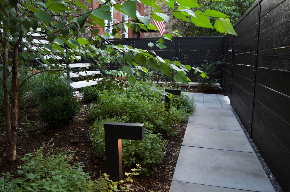 Photo of a small modern full sun backyard concrete paver landscaping in Chicago.