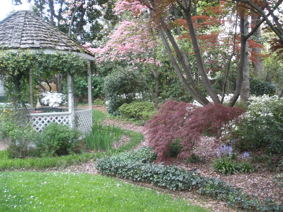 Design ideas for a mid-sized victorian partial sun backyard landscaping in Raleigh.