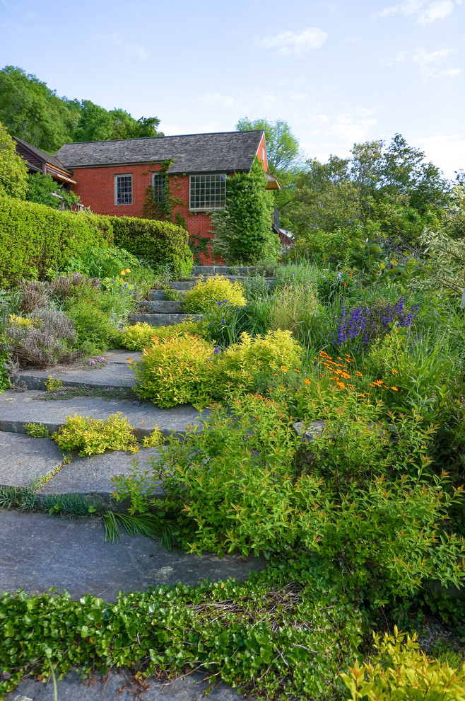 Design ideas for a farmhouse full sun backyard stone landscaping in New York.