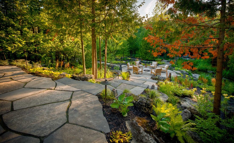 Imagen de jardín tradicional extra grande en otoño en patio trasero con exposición reducida al sol, adoquines de piedra natural y brasero