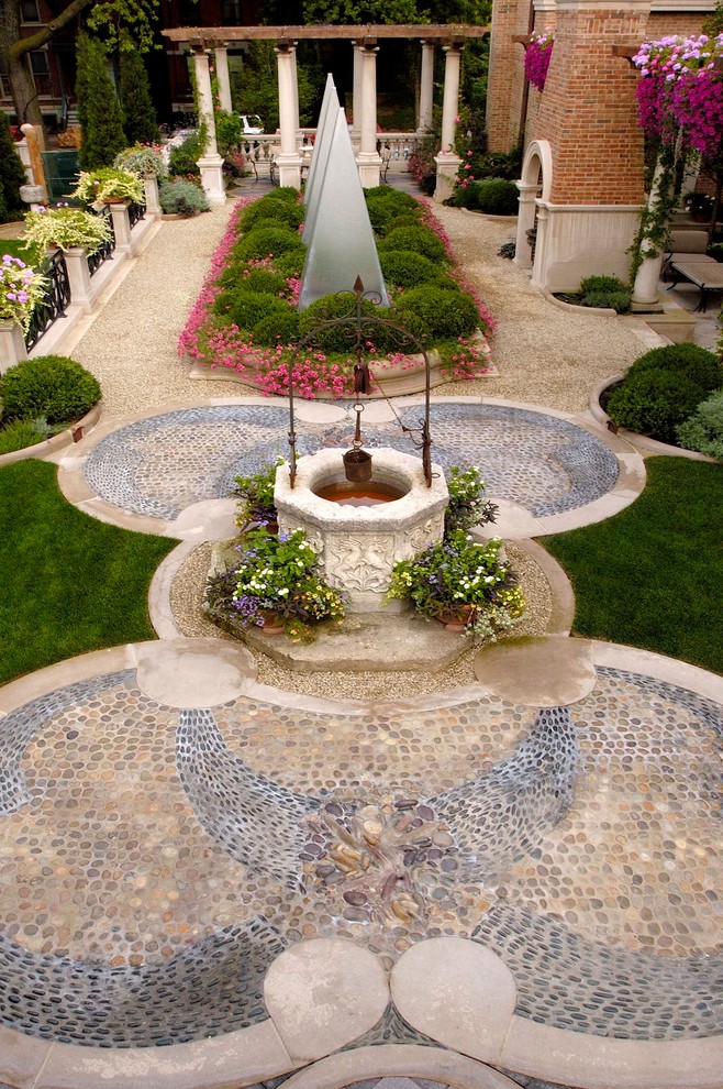 Aménagement d'un très grand jardin classique l'été avec des pavés en pierre naturelle.