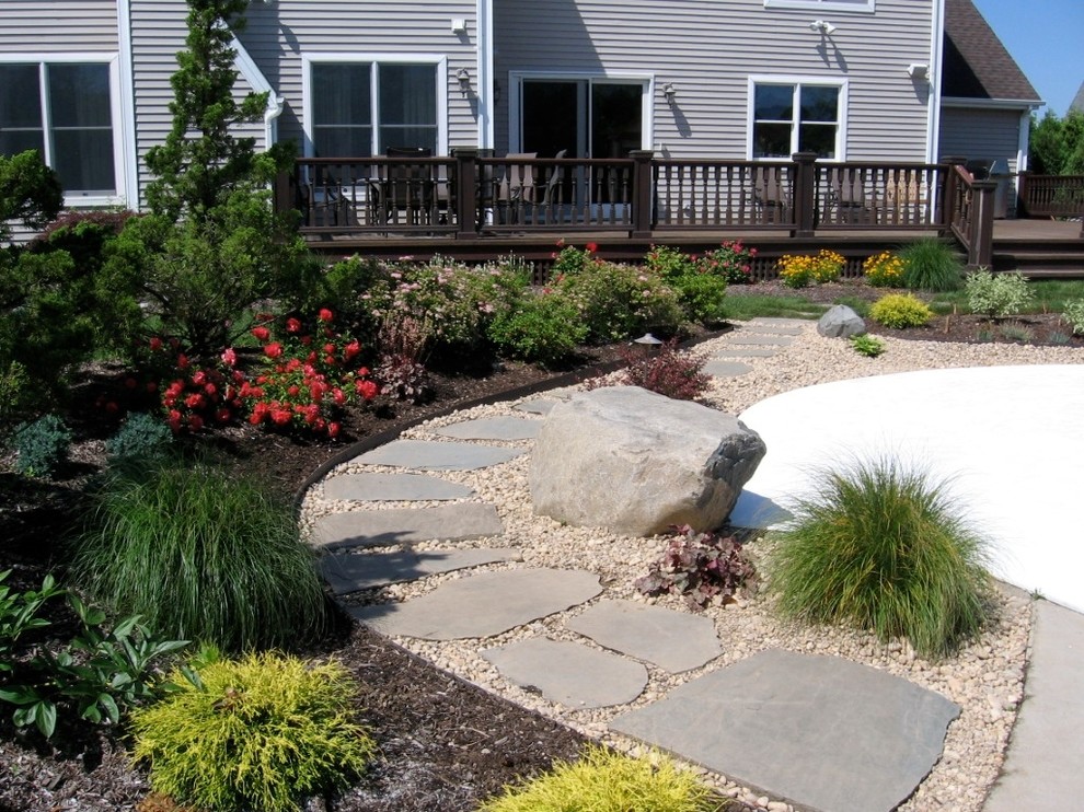 Idée de décoration pour un aménagement d'entrée ou allée de jardin tradition avec des pavés en pierre naturelle.