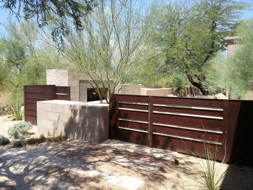 Photo of a medium sized modern back partial sun garden in Phoenix with natural stone paving.