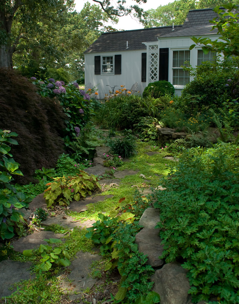 Exemple d'un jardin arrière chic avec une exposition ombragée et des pavés en pierre naturelle.