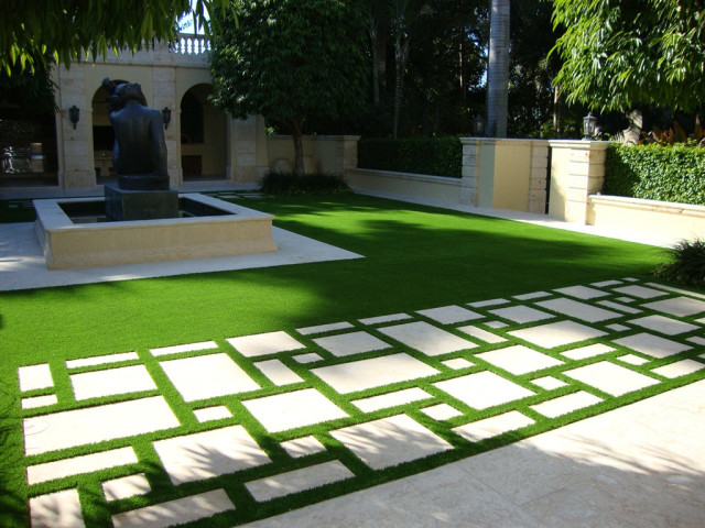 Modelo de acceso privado minimalista grande en verano en patio con fuente, exposición parcial al sol y adoquines de hormigón