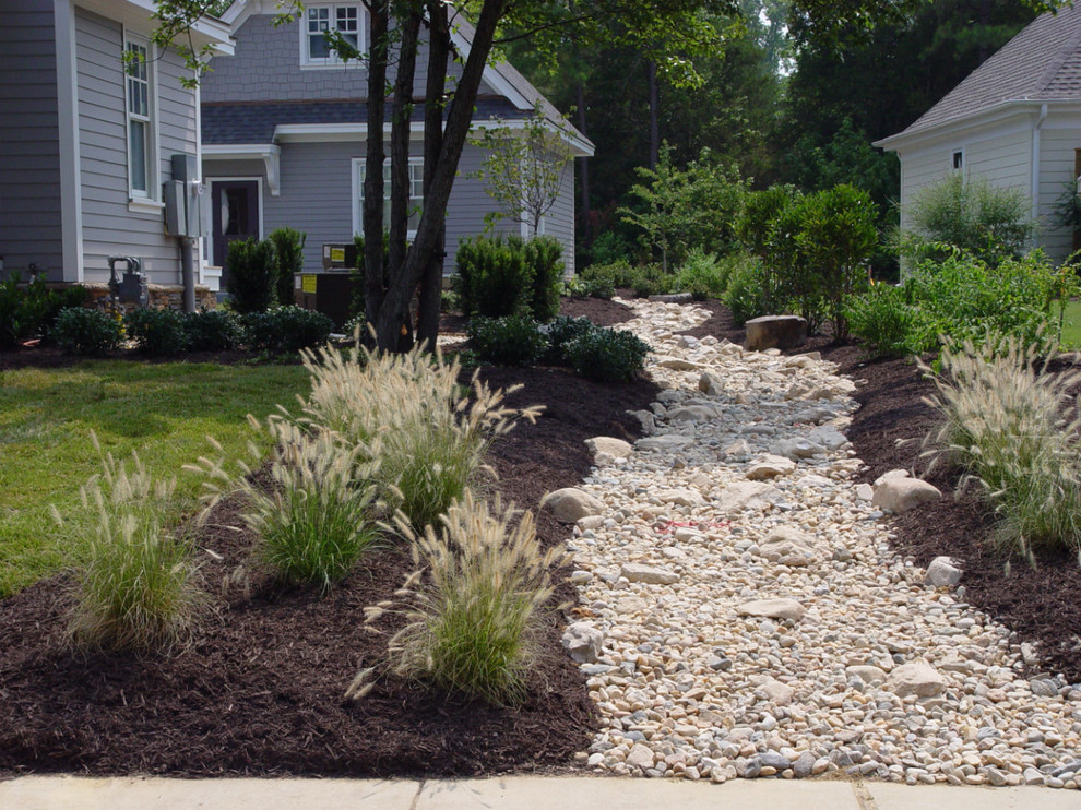 This is an example of a mid-sized traditional full sun side yard gravel landscaping in Richmond.