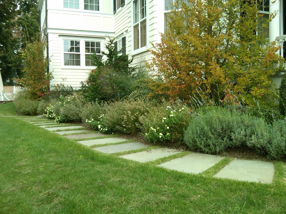 Photo of a large bohemian back formal partial sun garden for spring in New York with a garden path and natural stone paving.