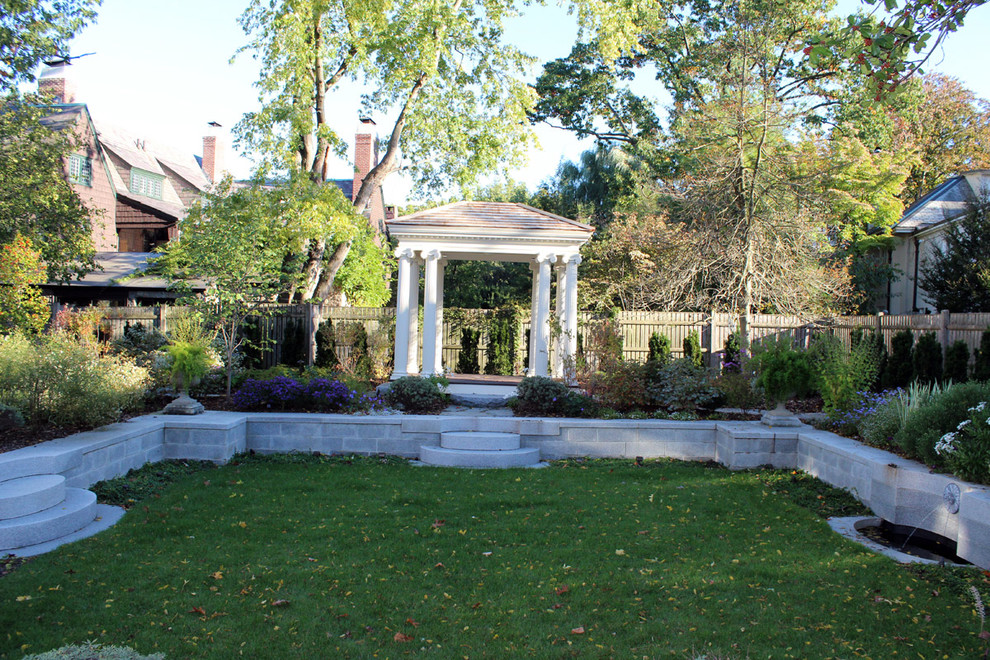 This is an example of a mid-sized traditional full sun backyard brick water fountain landscape in Boston.