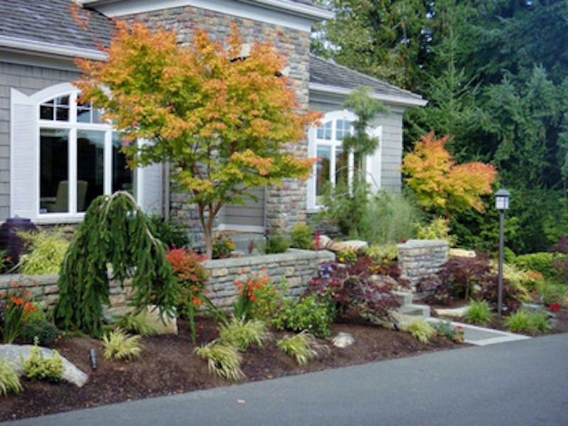 Photo of a medium sized classic front formal full sun garden for spring in Seattle with a garden path and natural stone paving.