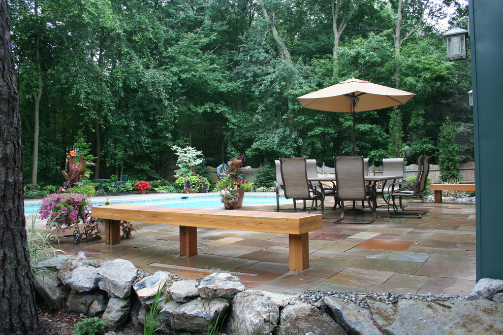 Small traditional back fully shaded garden for summer in Philadelphia with natural stone paving.