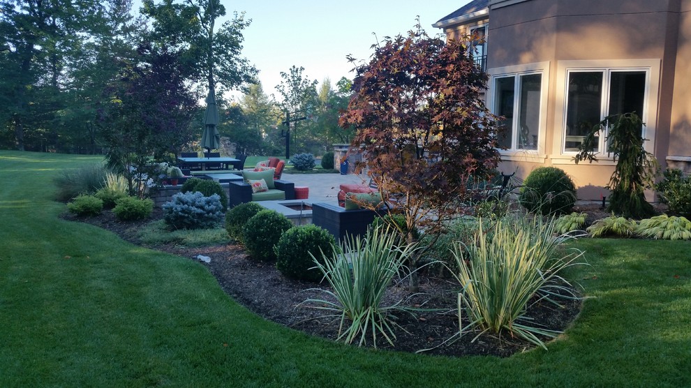 Photo of a mid-sized traditional full sun backyard concrete paver formal garden in New York for spring.