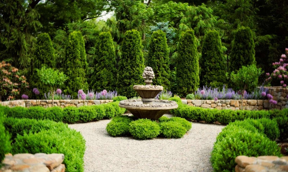 Esempio di un giardino formale tradizionale esposto a mezz'ombra di medie dimensioni e in cortile in estate con fontane e ghiaia