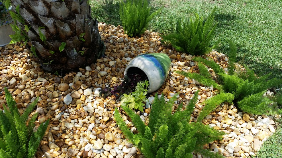 Пример оригинального дизайна: маленький солнечный регулярный сад на переднем дворе в стиле модернизм с растениями в контейнерах, хорошей освещенностью и покрытием из гравия для на участке и в саду