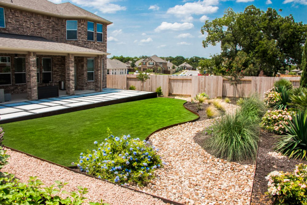 Ispirazione per un grande giardino stile americano esposto in pieno sole dietro casa in estate con pavimentazioni in cemento