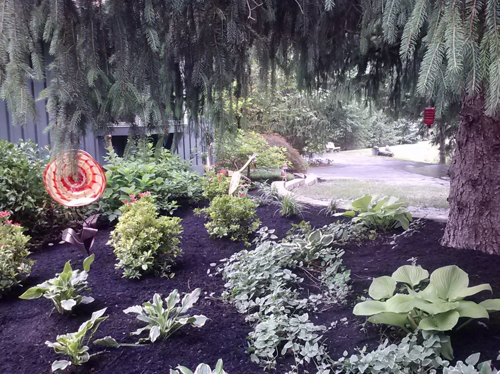 This is an example of a mid-sized eclectic shade backyard mulch garden path in Columbus for summer.