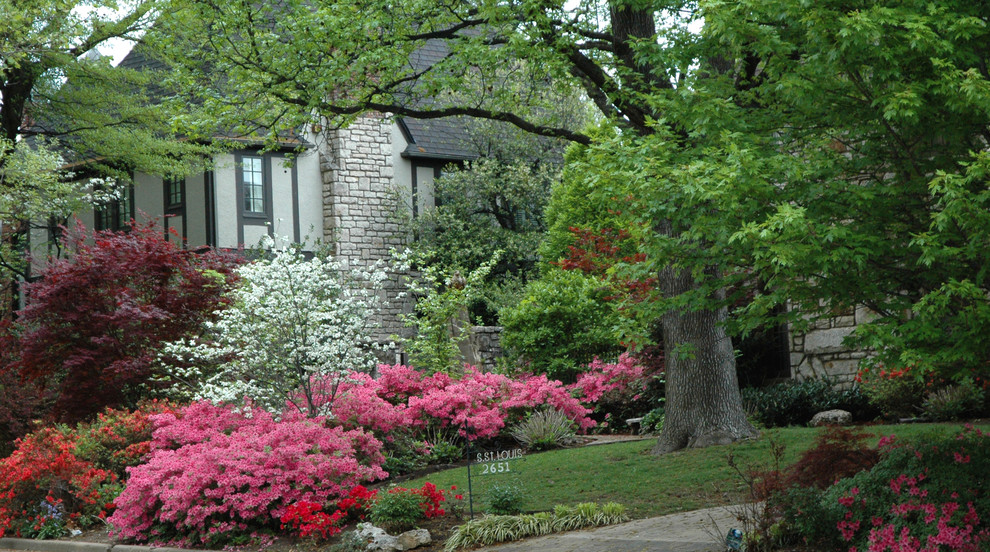 This is an example of a large traditional partial sun front yard brick landscaping in Other for spring.