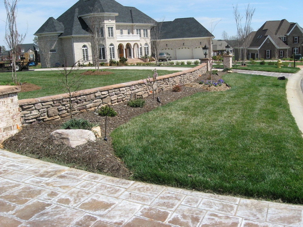 This is an example of a large traditional partial sun front yard stone landscaping in Charlotte for summer.