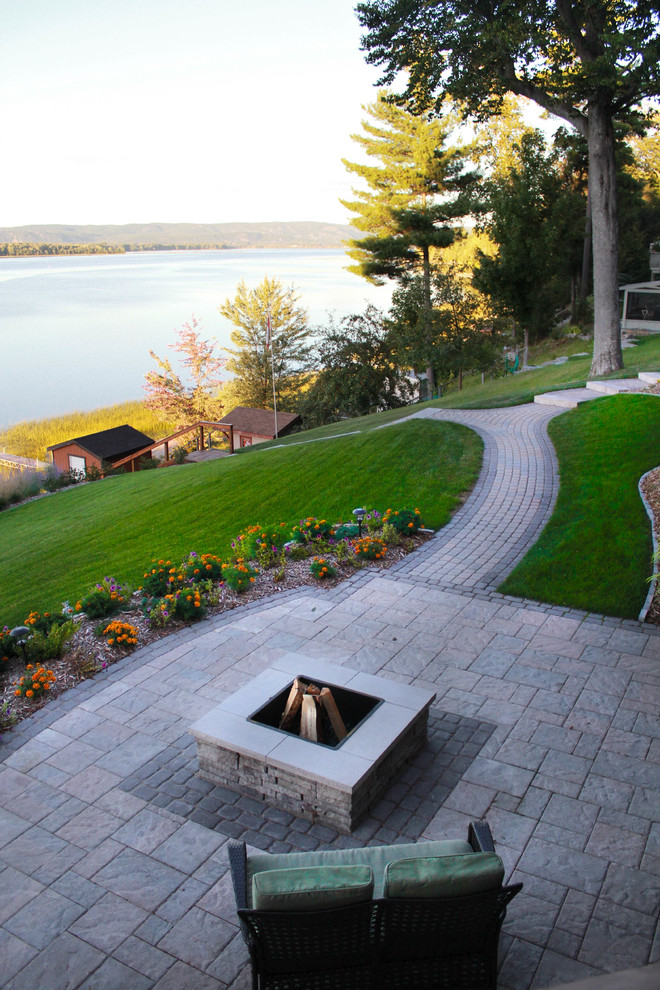 Photo of a mid-sized contemporary backyard stone retaining wall landscape in Ottawa for summer.