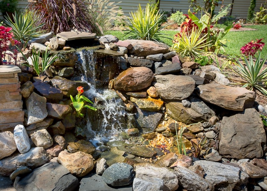 Photo of a mid-sized eclectic full sun front yard stone water fountain landscape in Other for fall.