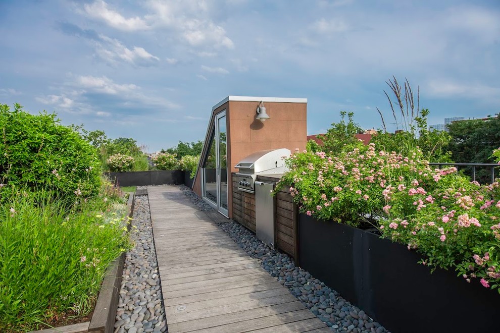 This is an example of a small coastal drought-tolerant and full sun rooftop garden path in New York with decking for spring.