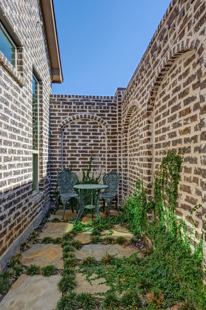 Foto di un piccolo giardino formale mediterraneo in ombra nel cortile laterale con un ingresso o sentiero e pavimentazioni in pietra naturale