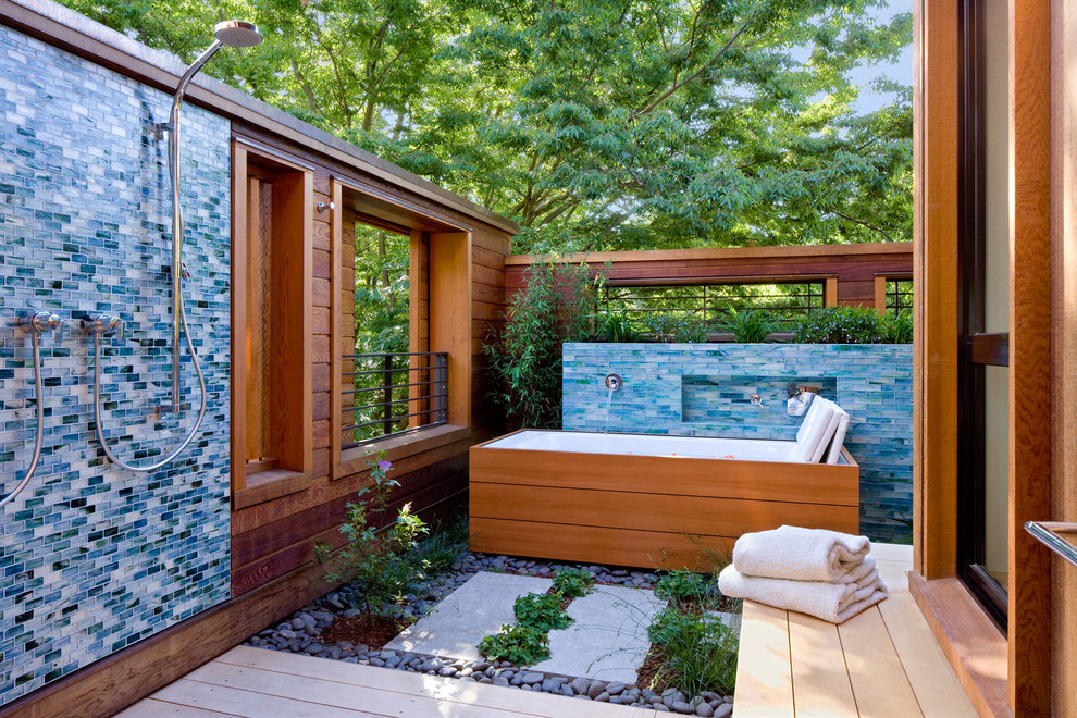 Réalisation d'un jardin arrière design avec une terrasse en bois.