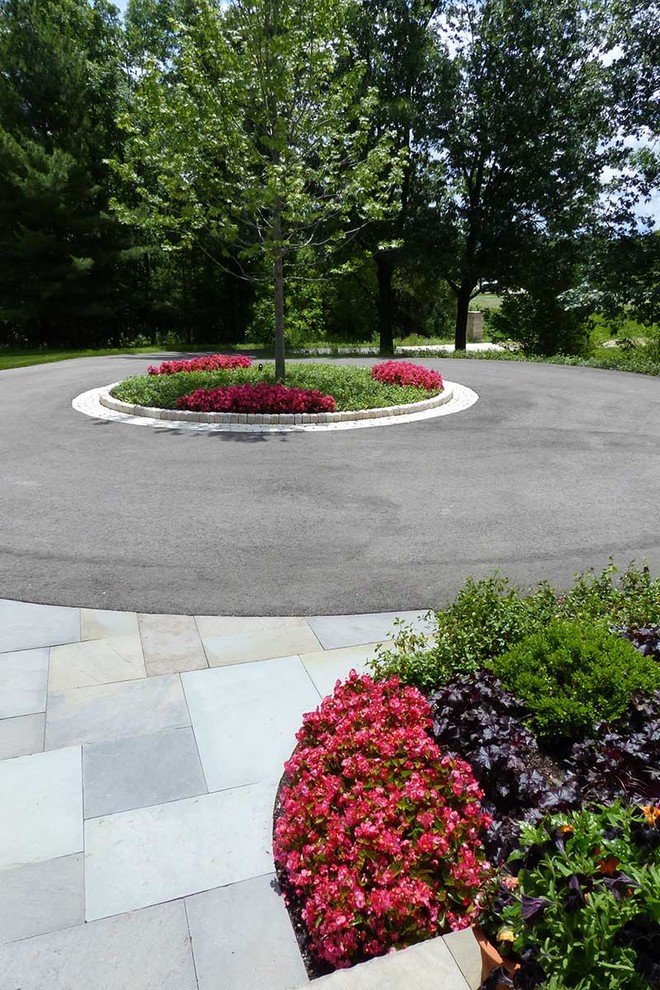 Photo of a large classic front xeriscape partial sun garden for summer in Chicago with a garden path and natural stone paving.