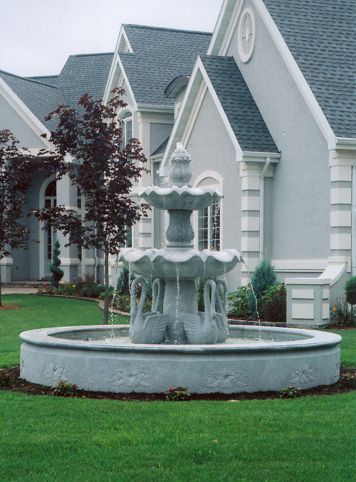 Photo of a huge traditional full sun front yard stone water fountain landscape in Milwaukee.