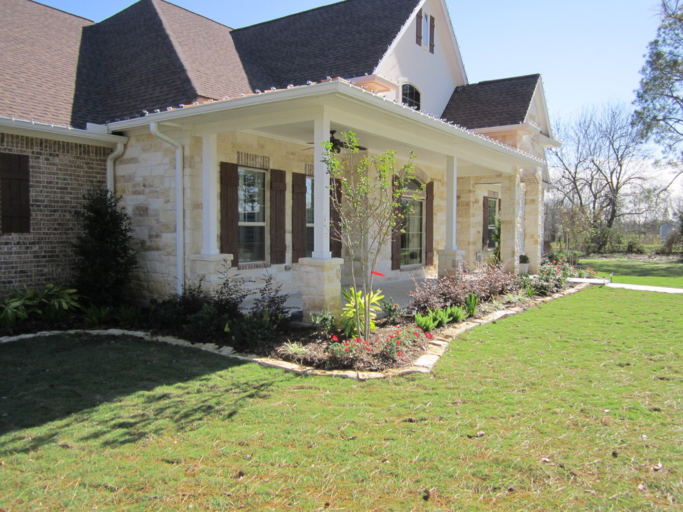 This is an example of a large classic front full sun garden in Houston.