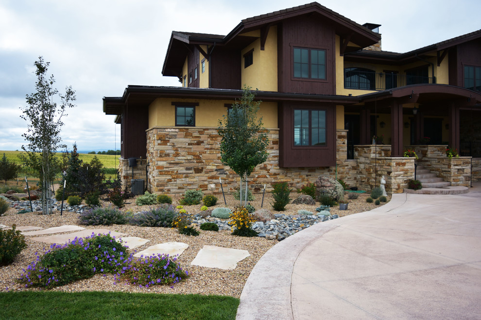 This is an example of a large traditional front xeriscape full sun garden in Other with a garden path and gravel.