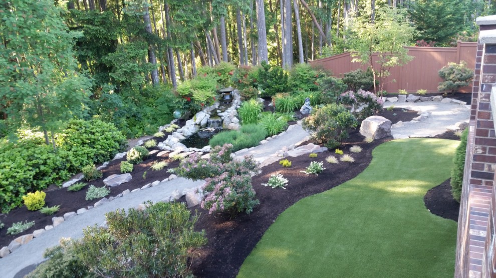 This is an example of a large classic back partial sun garden in Seattle with a garden path and gravel.