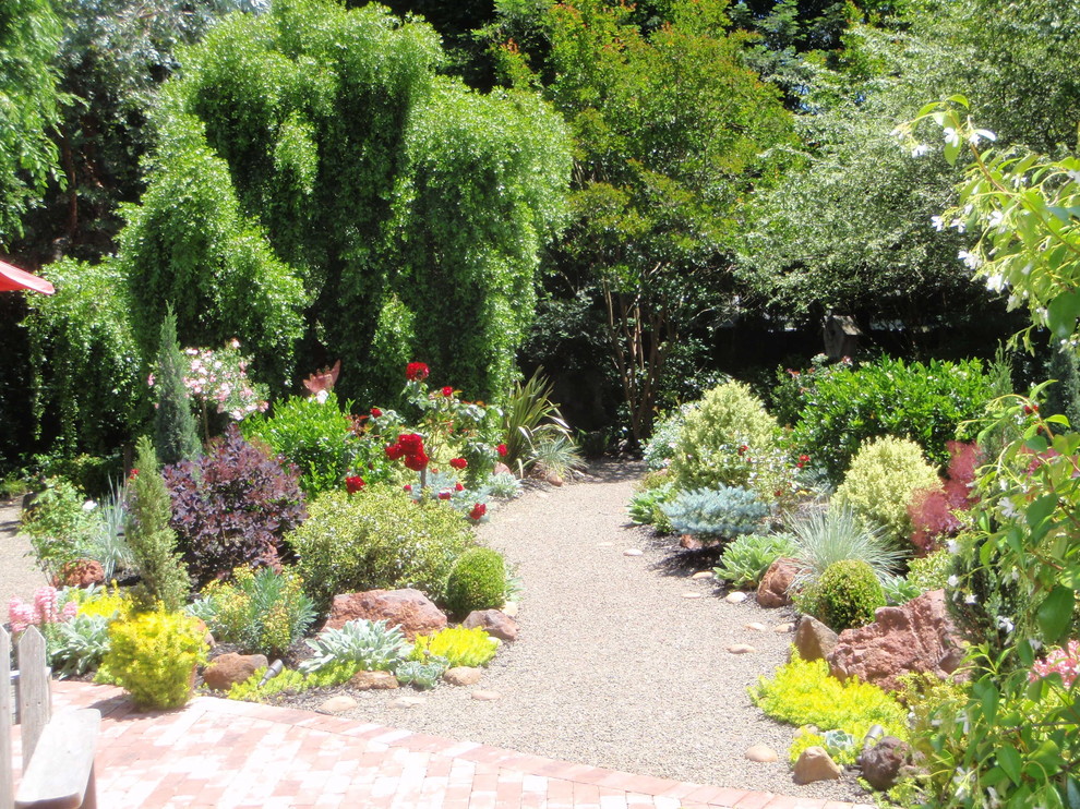 Exempel på en klassisk trädgård, med en fontän och grus