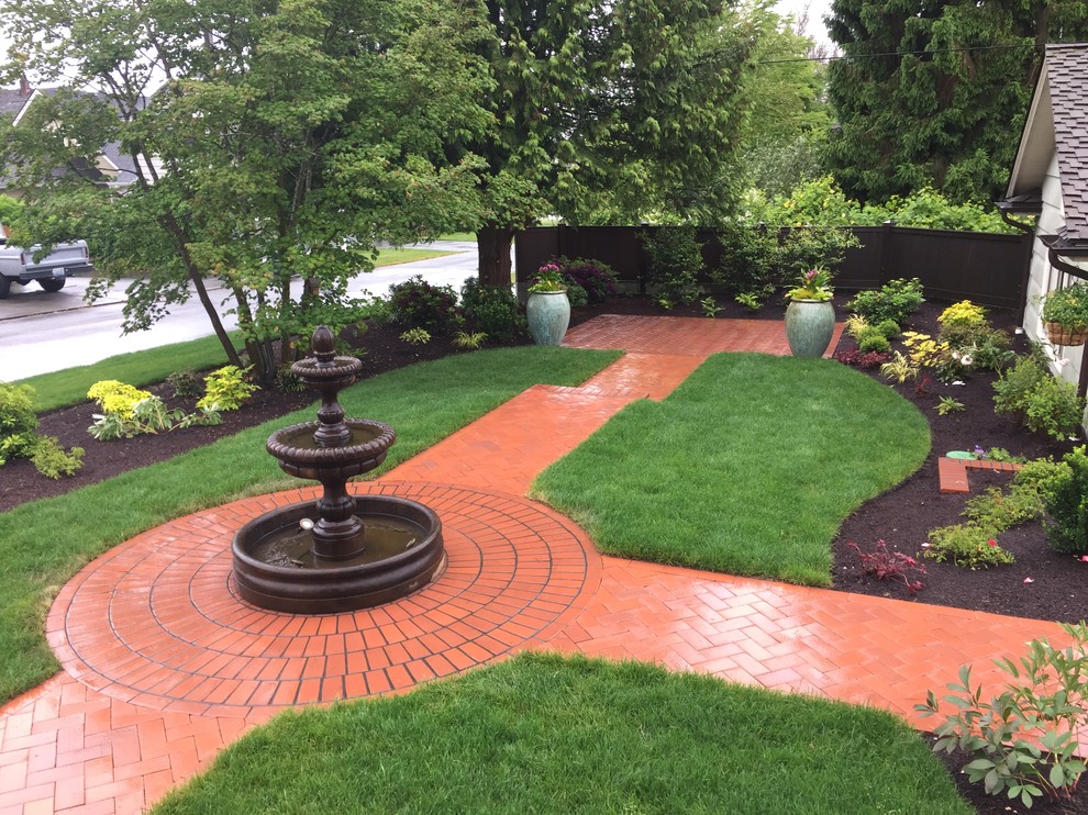 Großer Klassischer Garten neben dem Haus mit Wasserspiel, direkter Sonneneinstrahlung und Pflastersteinen in Seattle