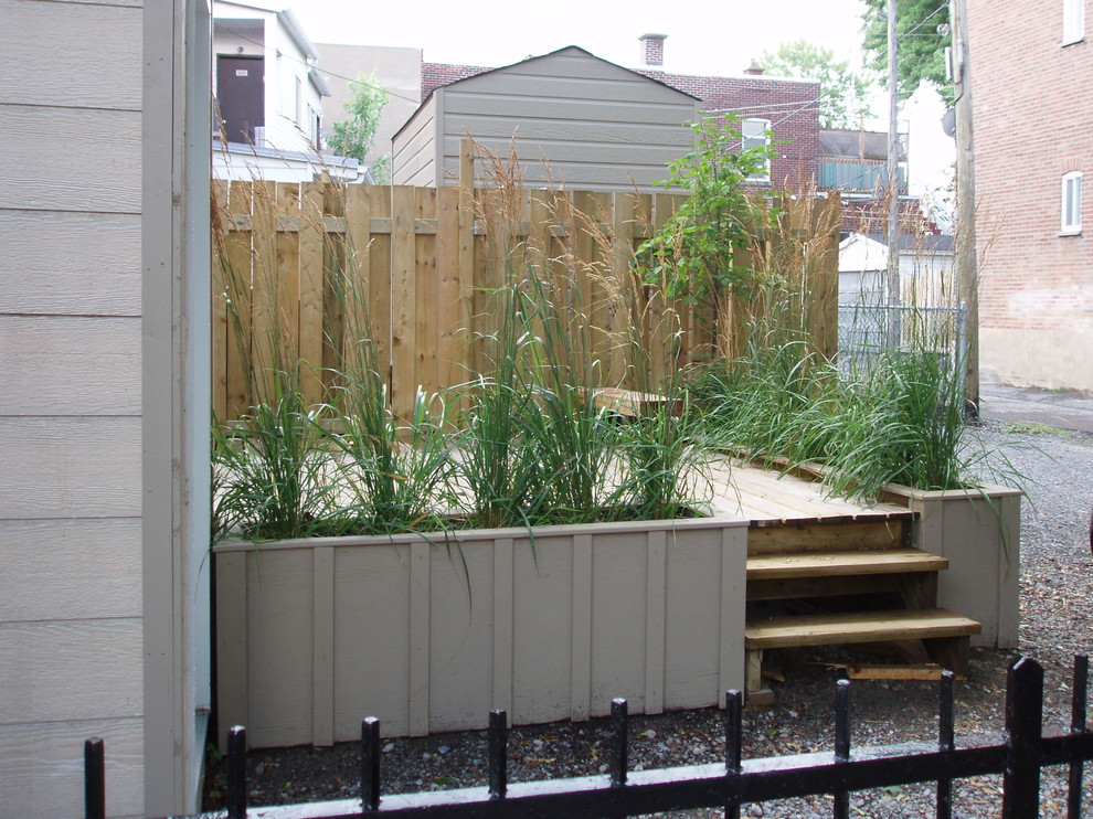 Inspiration pour un jardin arrière design avec une terrasse en bois.