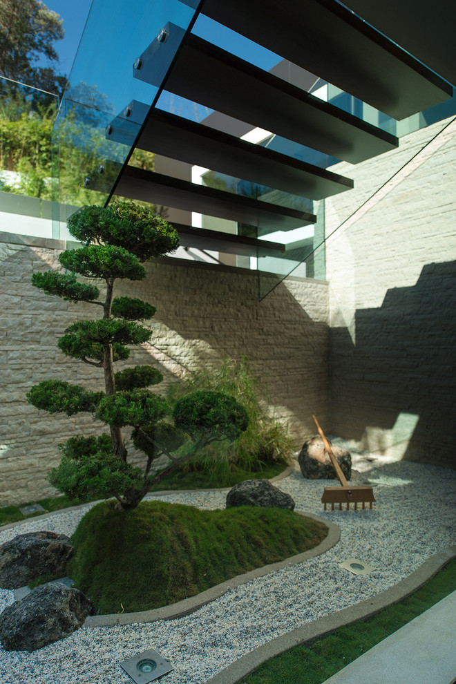 This is an example of an asian courtyard gravel landscaping in Los Angeles.