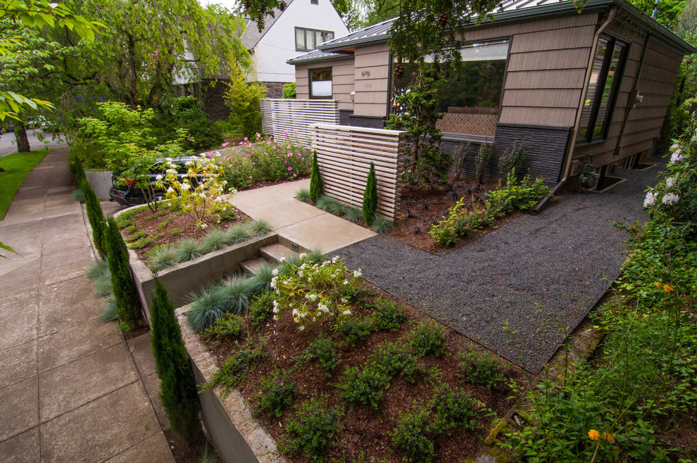 Photo of a small retro front formal partial sun garden for winter in Portland with a garden path and gravel.