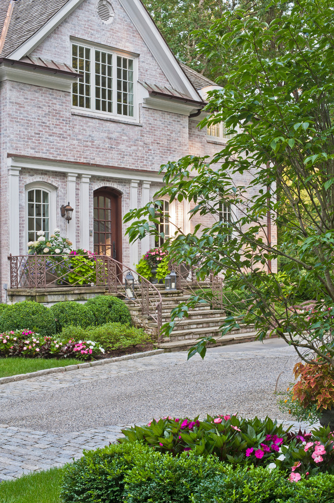 Diseño de jardín clásico extra grande en patio delantero con exposición parcial al sol y adoquines de piedra natural