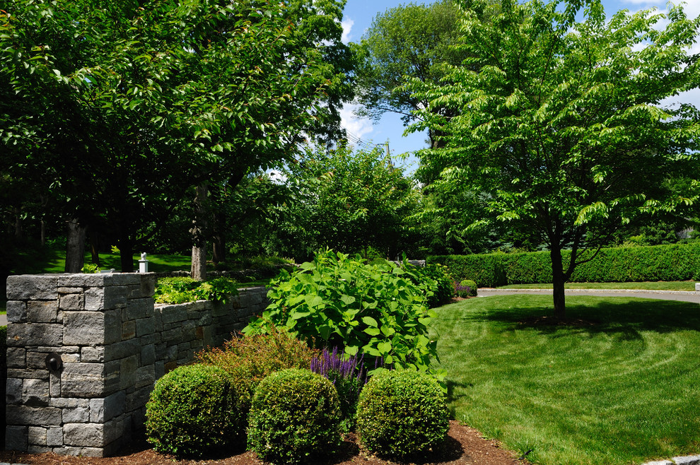 Ispirazione per un giardino formale country esposto a mezz'ombra di medie dimensioni e davanti casa con un muro di contenimento e pacciame