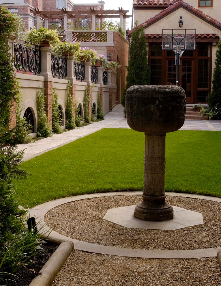 Esempio di un ampio giardino formale tradizionale in cortile in estate con pavimentazioni in pietra naturale