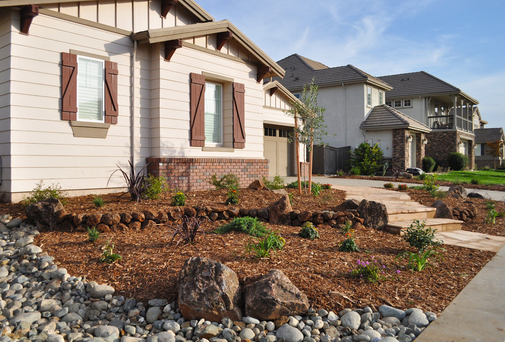 Inspiration for a mid-sized traditional full sun front yard stone landscaping in Sacramento.
