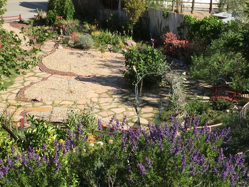 Idéer för att renovera en mellanstor medelhavsstil trädgård i full sol som tål torka och framför huset, med naturstensplattor