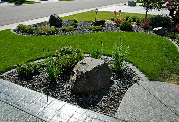This is an example of a medium sized classic front driveway full sun garden for spring in Calgary with concrete paving.