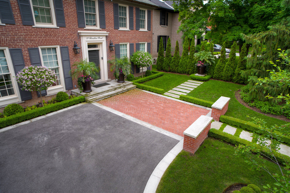 Photo of a large contemporary partial sun front yard stone landscaping in Toronto for summer.