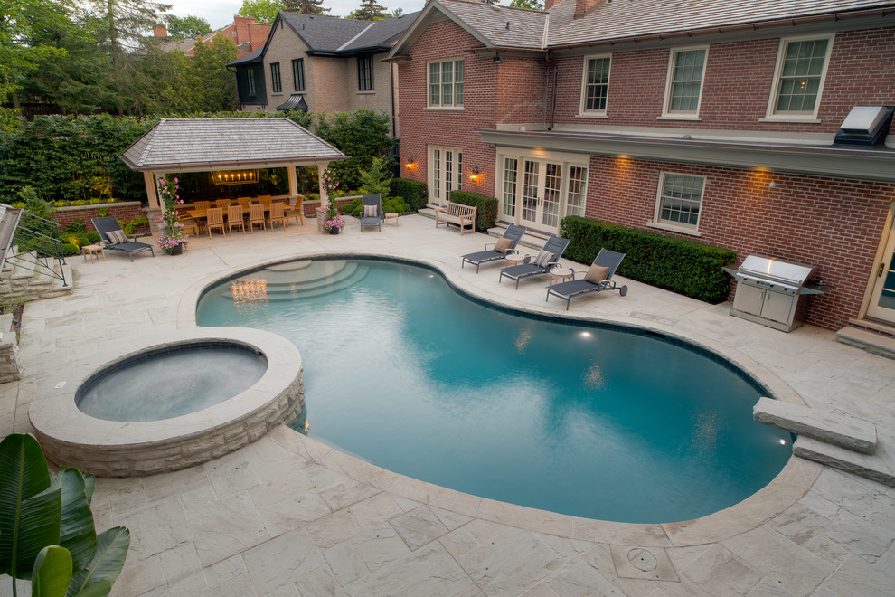 Immagine di una grande piscina contemporanea dietro casa con pavimentazioni in pietra naturale